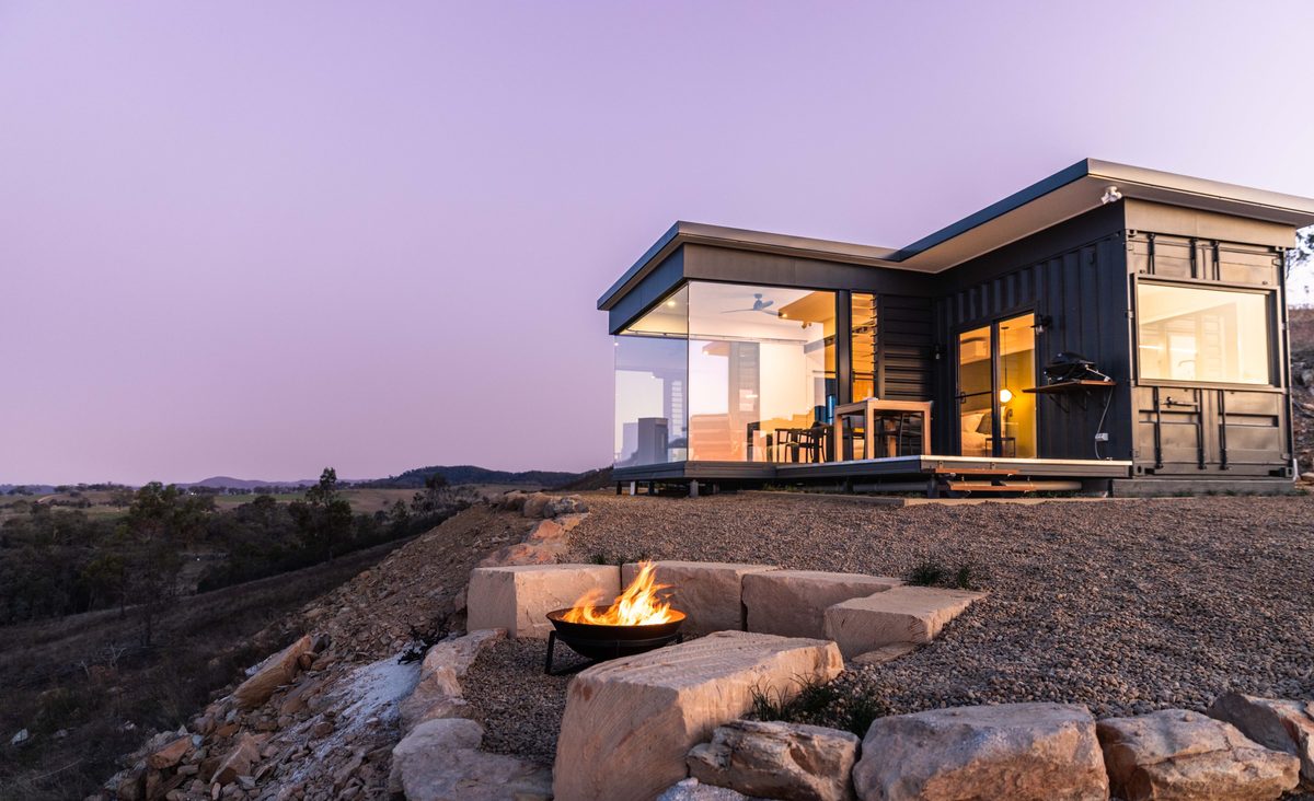 Elouera: black clad home on a ridge at dusk